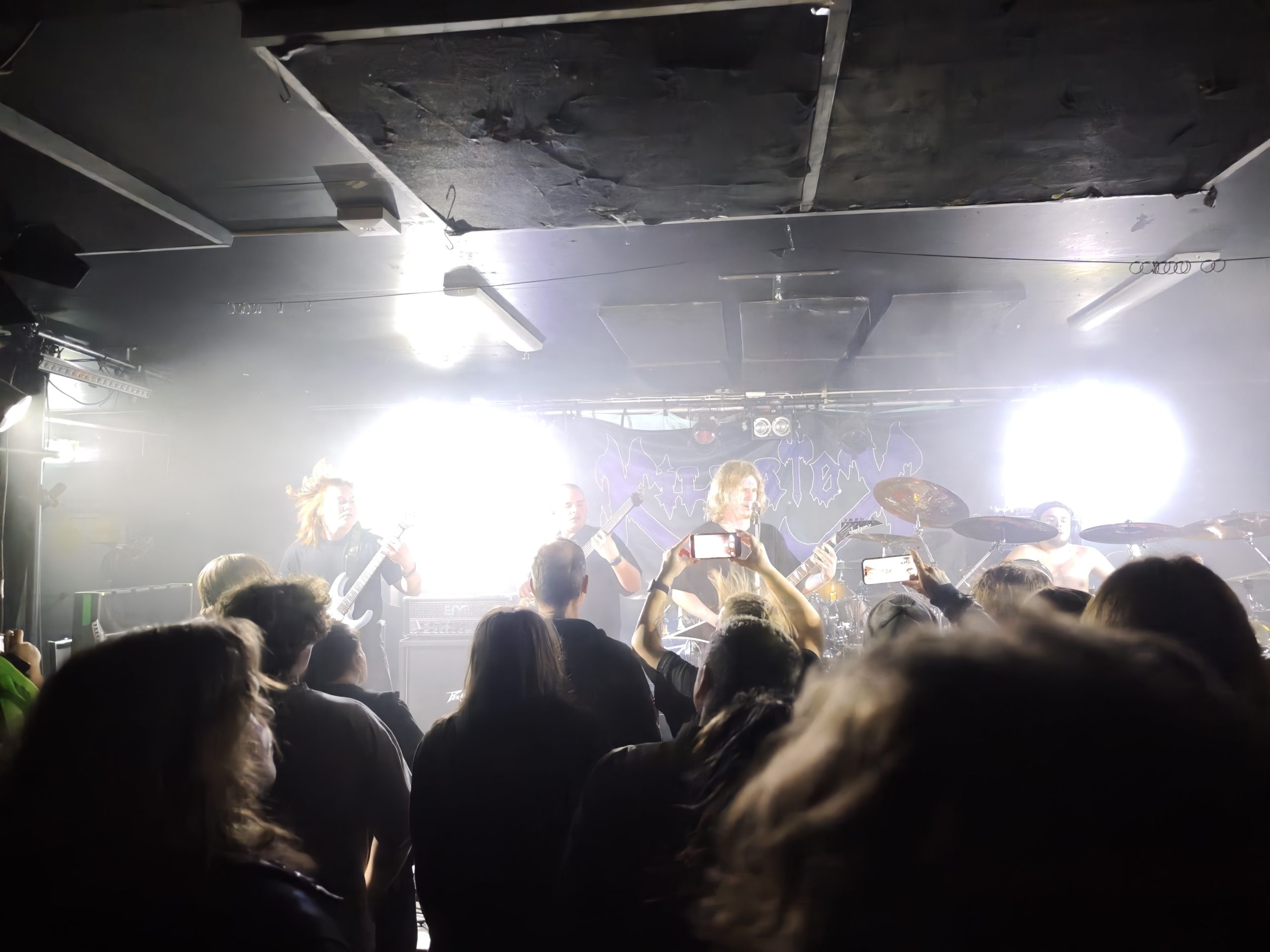 Scenen är klädd i vitt ljus. Ett band står och spelar