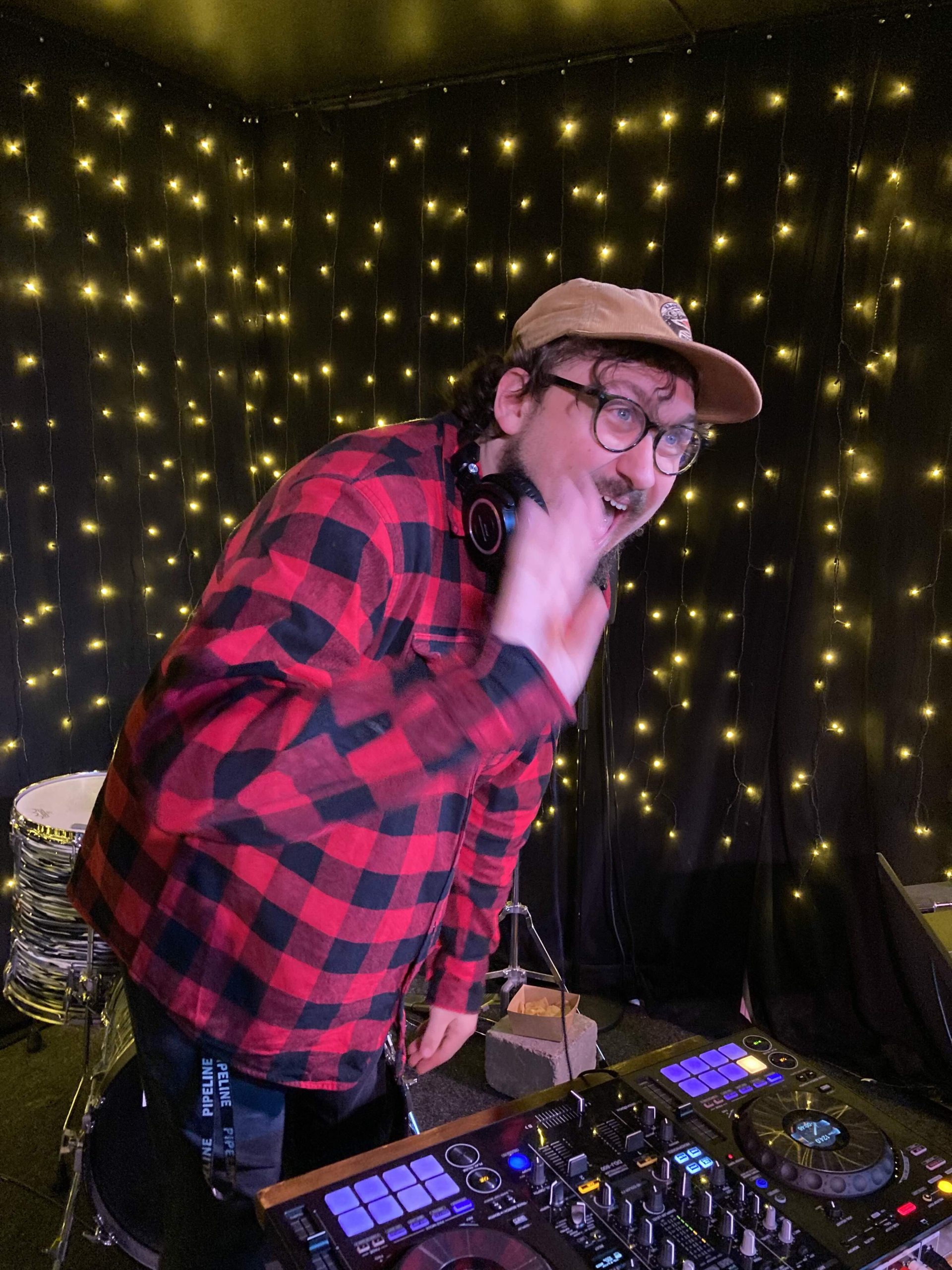 En glad man vid ett DJ-bord vinkar