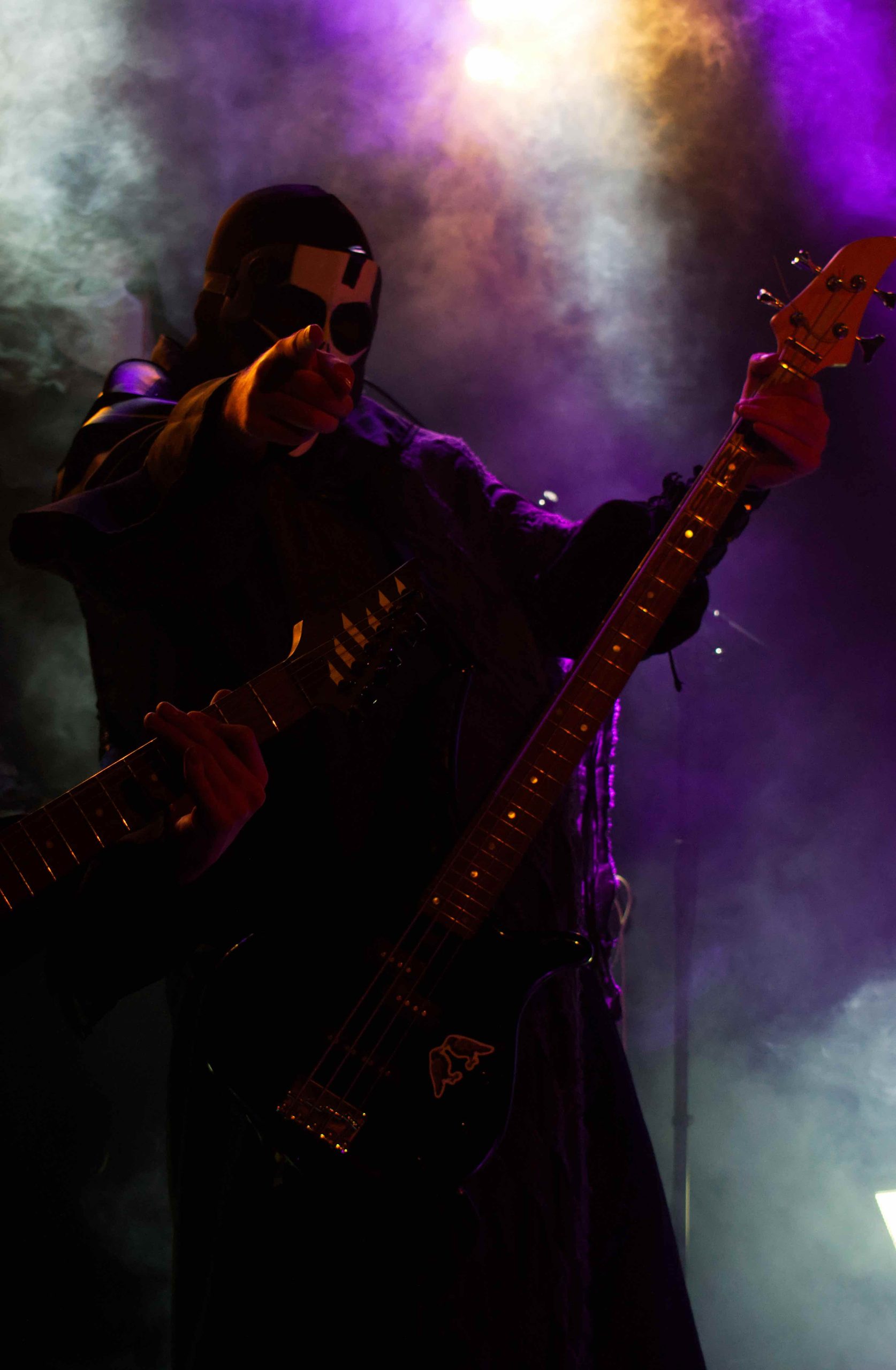 Blackworns ena gitarrist, iklädd kåpa och mask, pekar mot kameran.