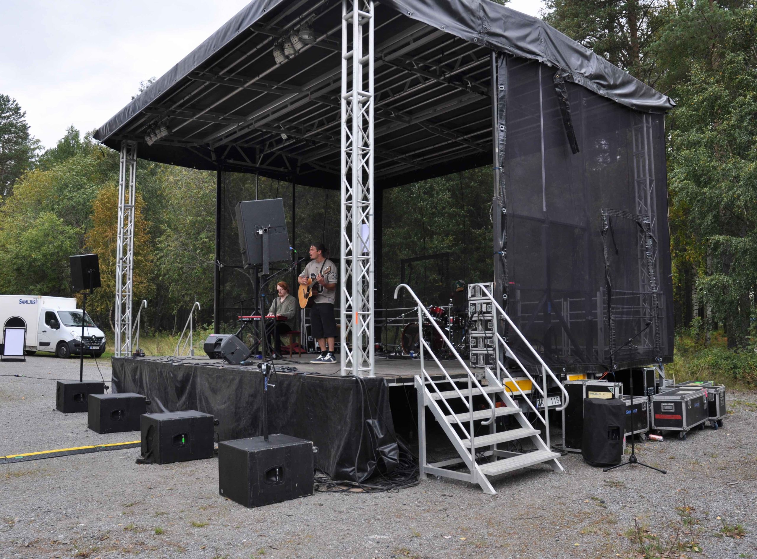 Scenen är klädd med svart tyg. På scenen står Josef Love med sin gitarr. Bredvid honom sitter en person med keyboard och längst bak skymtas en trummis vid ett trumset.