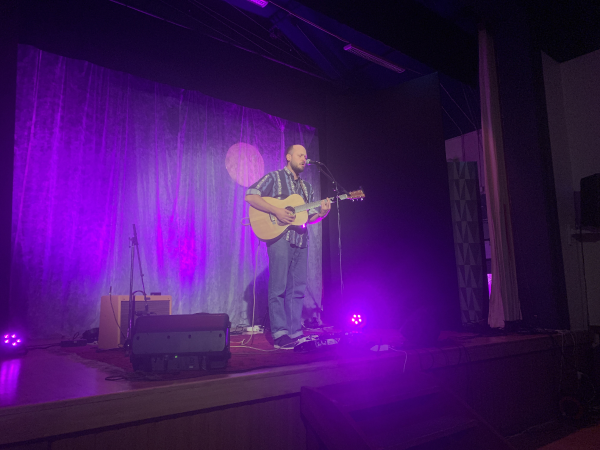 Johan AIrijoki står på scen med en gitarr framför sig